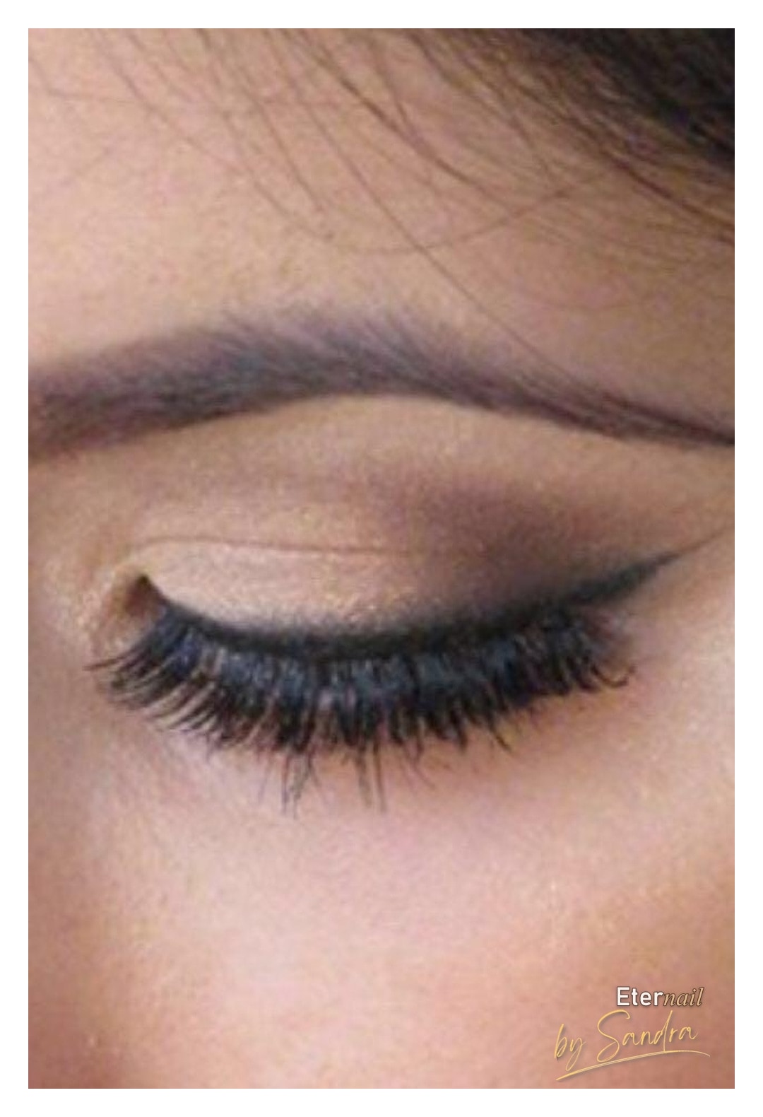 Close-up of gold eyeshadow with winged liner and false lashes