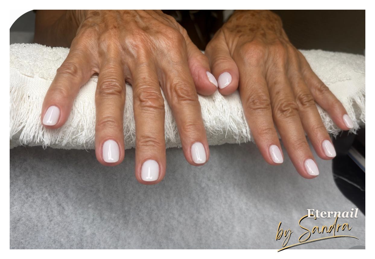 Natural nude gel manicure, both hands resting on a towel